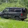 Wavecamper VW T6.1 LAST EDITION 4x4 Campervan mit Reserverad und Geländereifen auf einer Wiese im Wald