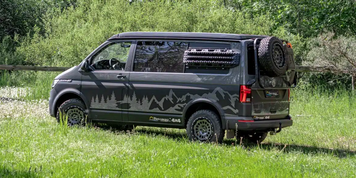 Wavecamper VW T6.1 LAST EDITION 4x4 Campervan mit Reserverad und Geländereifen auf einer Wiese im Wald