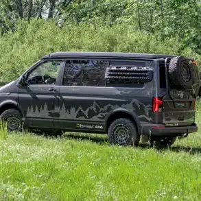 Wavecamper VW T6.1 LAST EDITION 4x4 Campervan mit Reserverad und Geländereifen auf einer Wiese im Wald