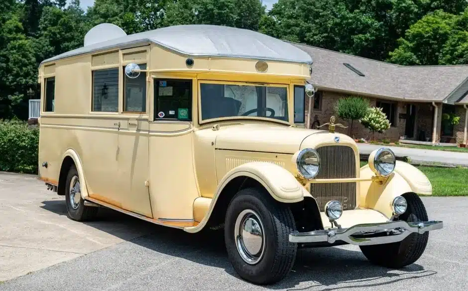 Cremefarbener 1927 Studebaker House Car mit verchromten Scheinwerfern und Wohnaufbau vor einem Wohnhaus