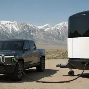 Aboard T4 Travel Trailer neben einem elektrischen Pickup in einer Berglandschaft