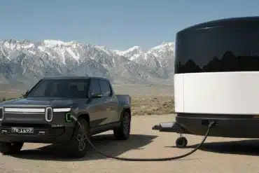 Aboard T4 Travel Trailer neben einem elektrischen Pickup in einer Berglandschaft
