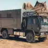 Grauer Acela Monterra GL 4x4 KRUG Expedition mit Wohnkabine und großen Offroad-Reifen in einer felsigen Landschaft