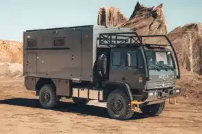 Grauer Acela Monterra GL 4x4 KRUG Expedition mit Wohnkabine und großen Offroad-Reifen in einer felsigen Landschaft