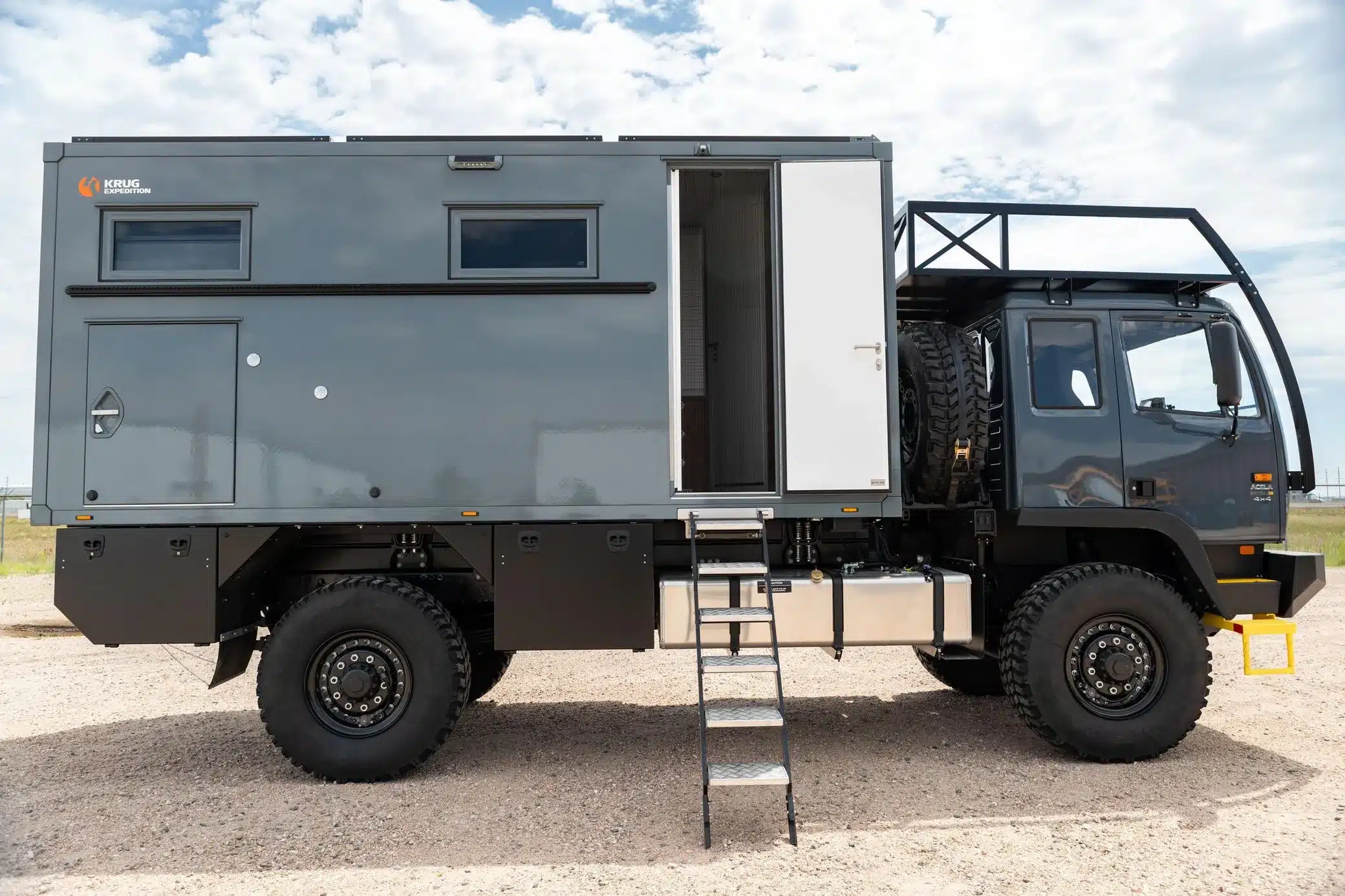 Grauer Acela Monterra GL 4x4 KRUG Expedition mit Wohnmodul, Offroad-Reifen und Leiter in Seitenansicht