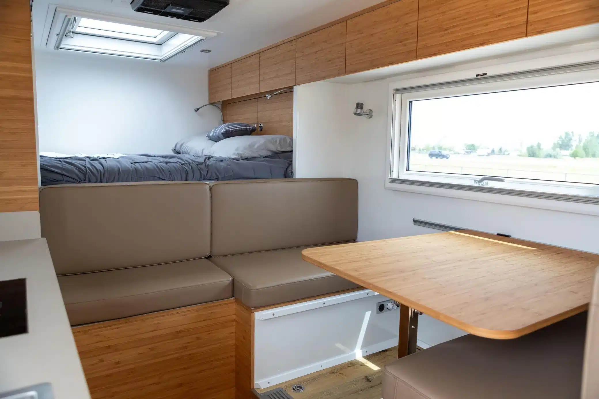 Innenraum des Acela Monterra GL 4x4 KRUG Expedition mit Dinette, Holzmöbeln und Bett