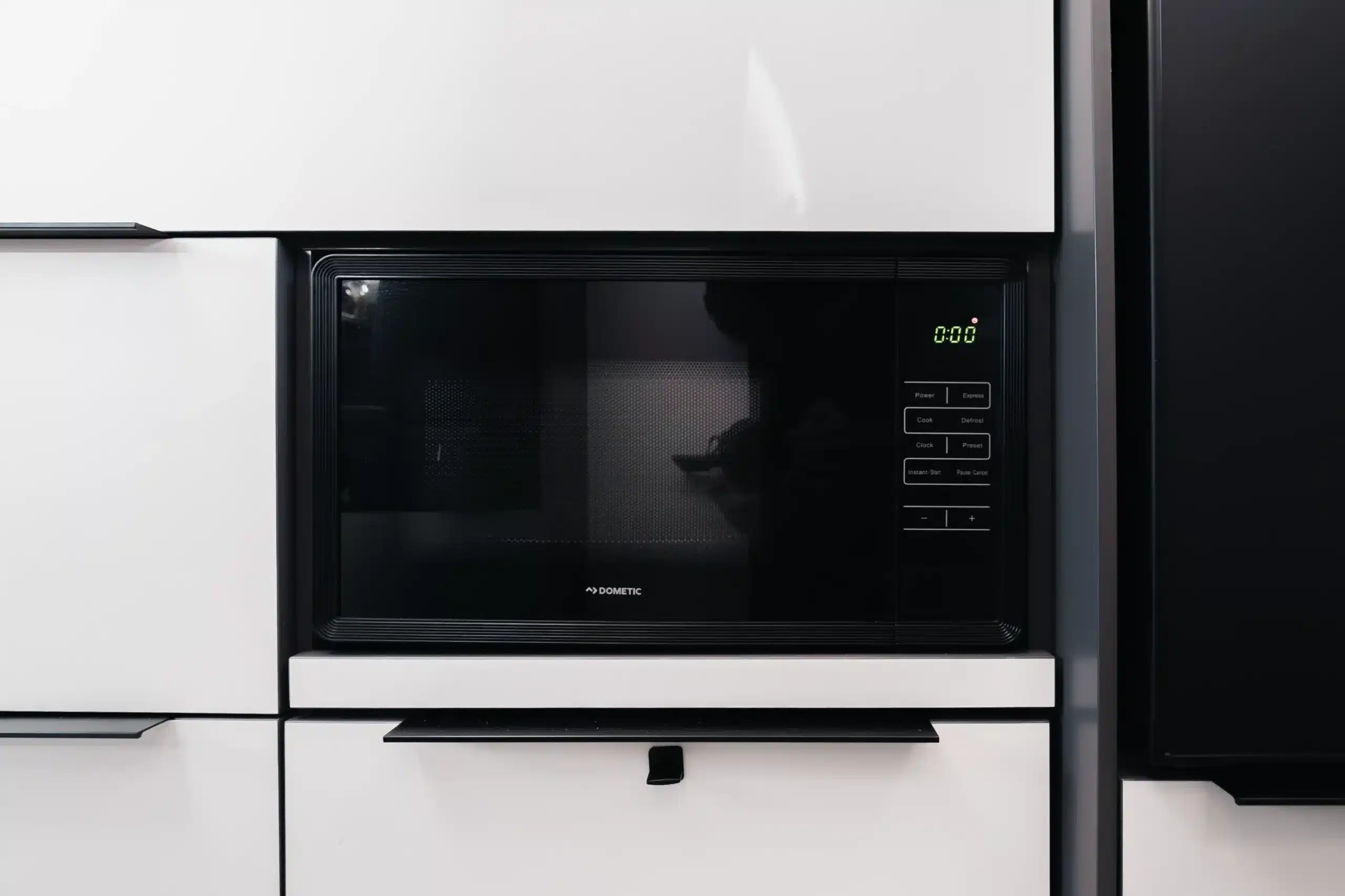 Schwarzes DOMETIC 3-in-1-Küchengerät in der weißen Küchenzeile eines Campers