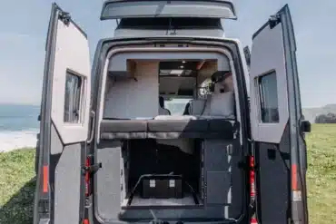 Heckansicht des ADVENTURE 6XR Campers mit geöffneten Türen, ausgeklapptem Hubdach und Schlafbereich