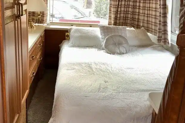 Heckschlafzimmer des Airstream 290 Motorhomes von 1985 mit Doppelbett, Holzschränken und Fenstern