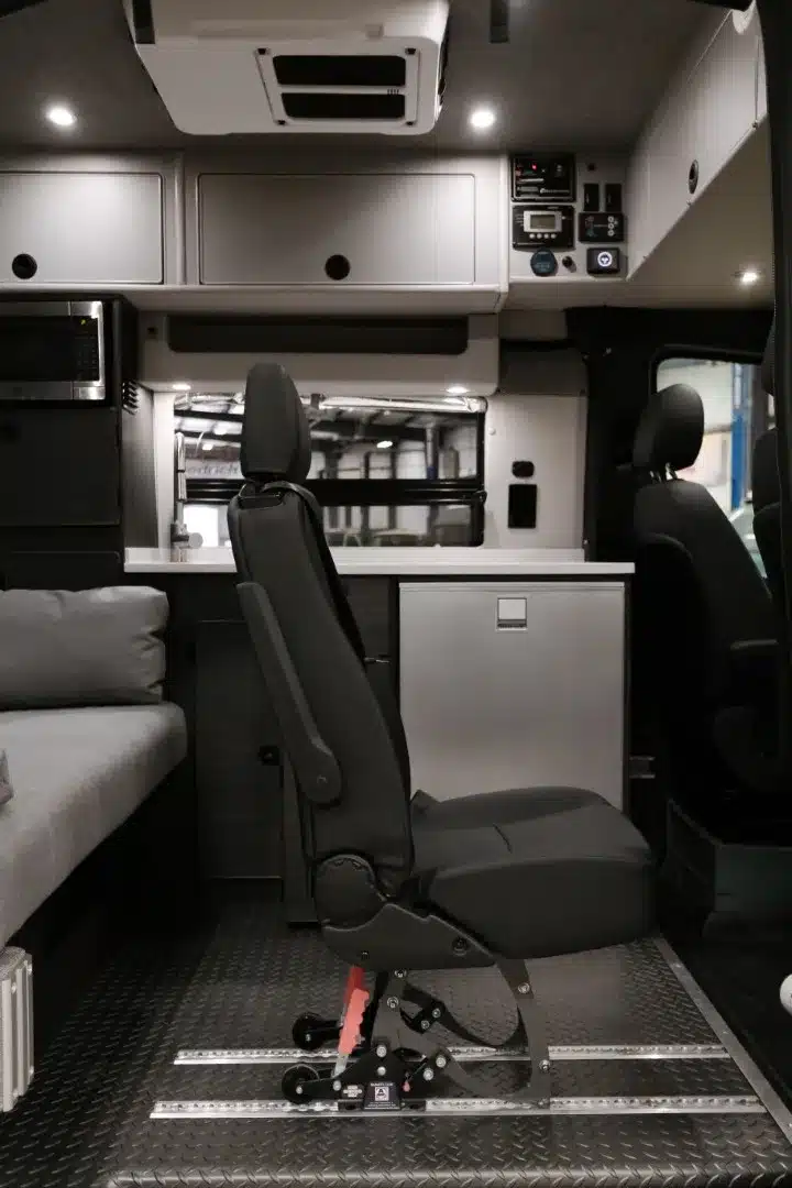 Innenraum eines ausgebauten Mercedes-Benz Sprinter-Campervans mit herausnehmbarem Sitz und Stauraum