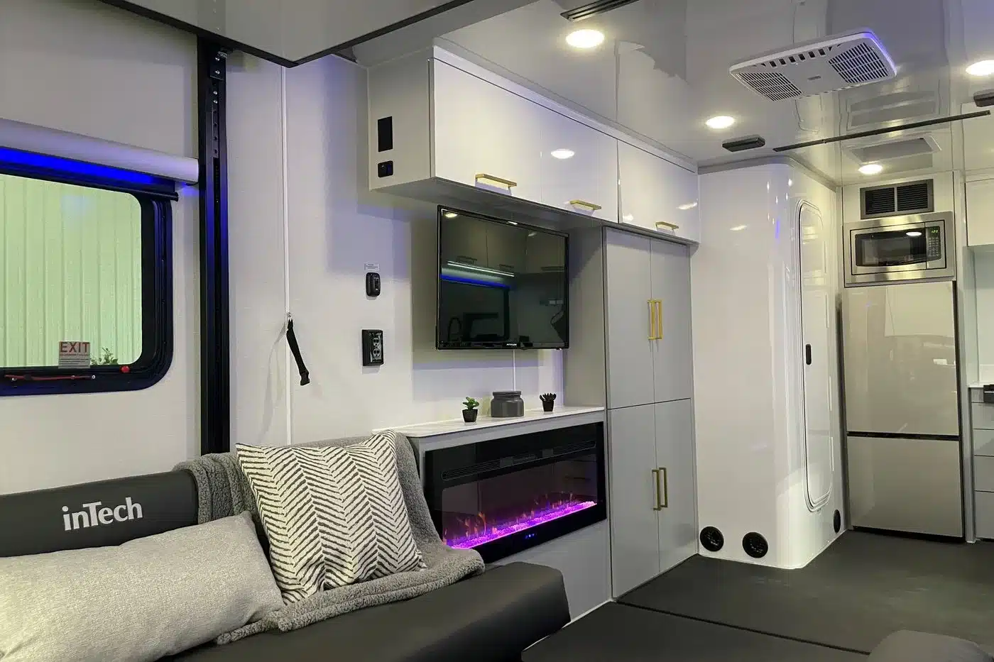 Innenraum eines Black Wing 826-X mit Sofa, Fernseher, elektrischem Kamin, Schränken und Küchenbereich