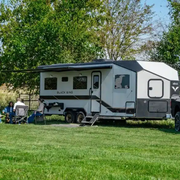 Black Wing 830-X Toy Hauler mit UTV und Pick-up auf einer Wiese