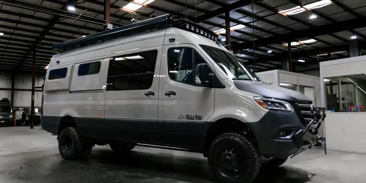 Weißer 4x4 Mercedes-Benz Sprinter-Camper von Field Van mit Offroad-Reifen, Frontstoßfänger, Dachträger und LED-Leuchten