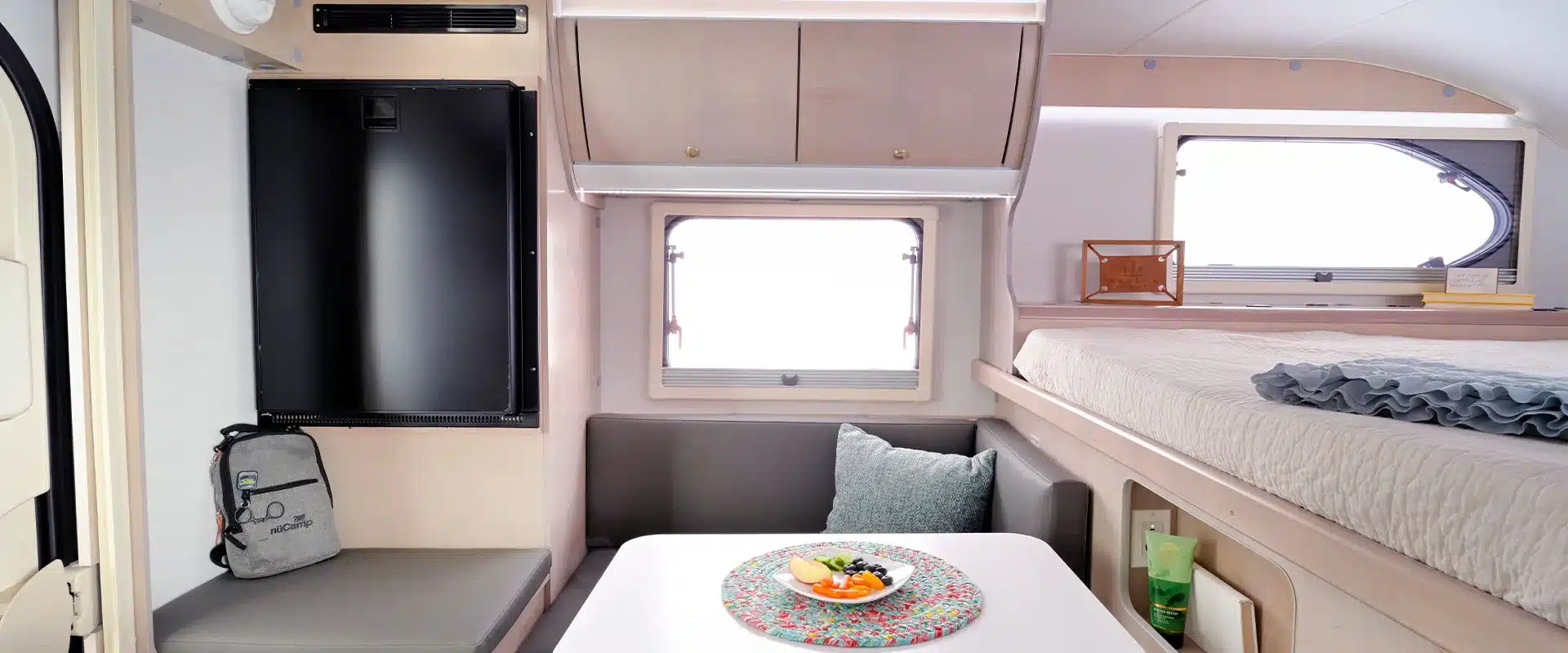 Innenraum des Cirrus 620 Truck Campers mit Sitzgruppe, Tisch, Küchenbereich und Bett