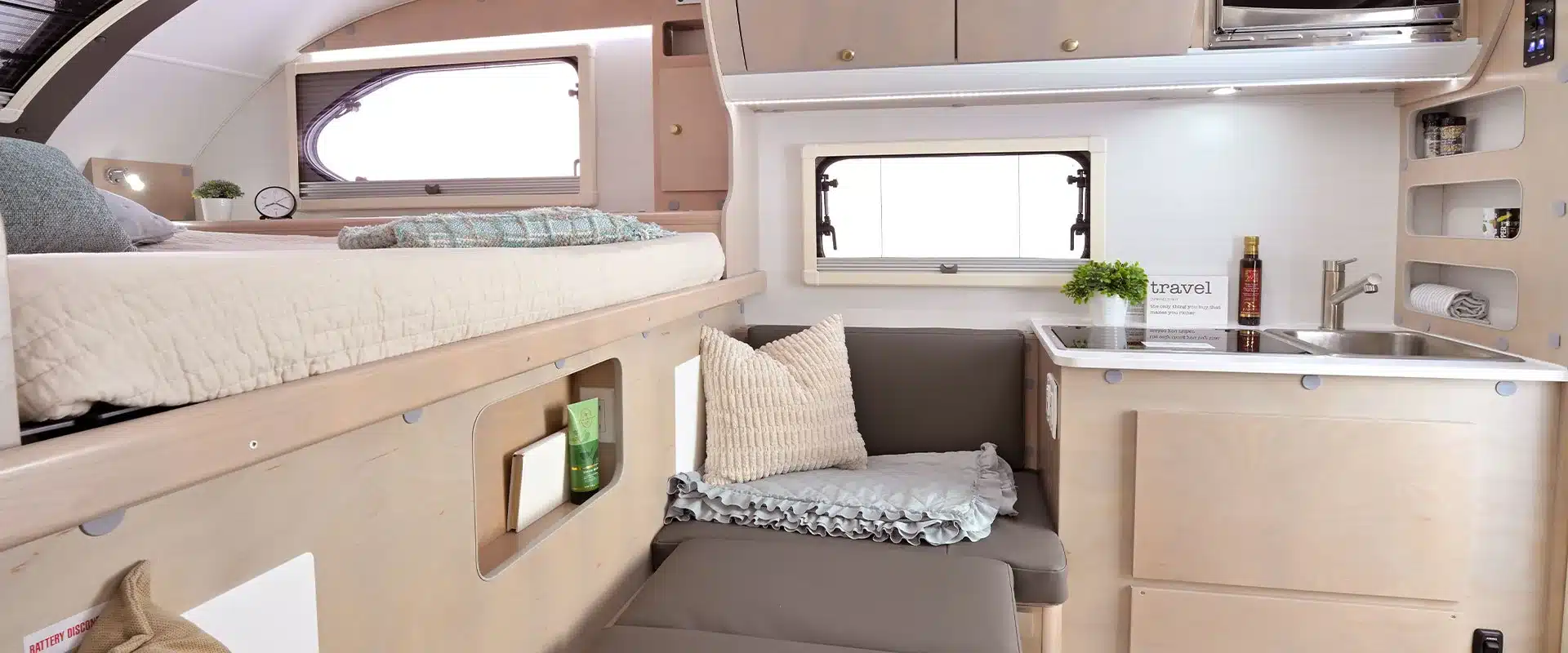 Innenraum des 2026 Cirrus 620 Truck Campers mit Bett, Sitzgruppe und Küche