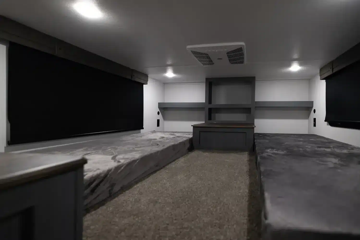 Innenansicht eines Puma Vista Destination Trailers mit zwei Betten, Stauraum und Deckenlüftung