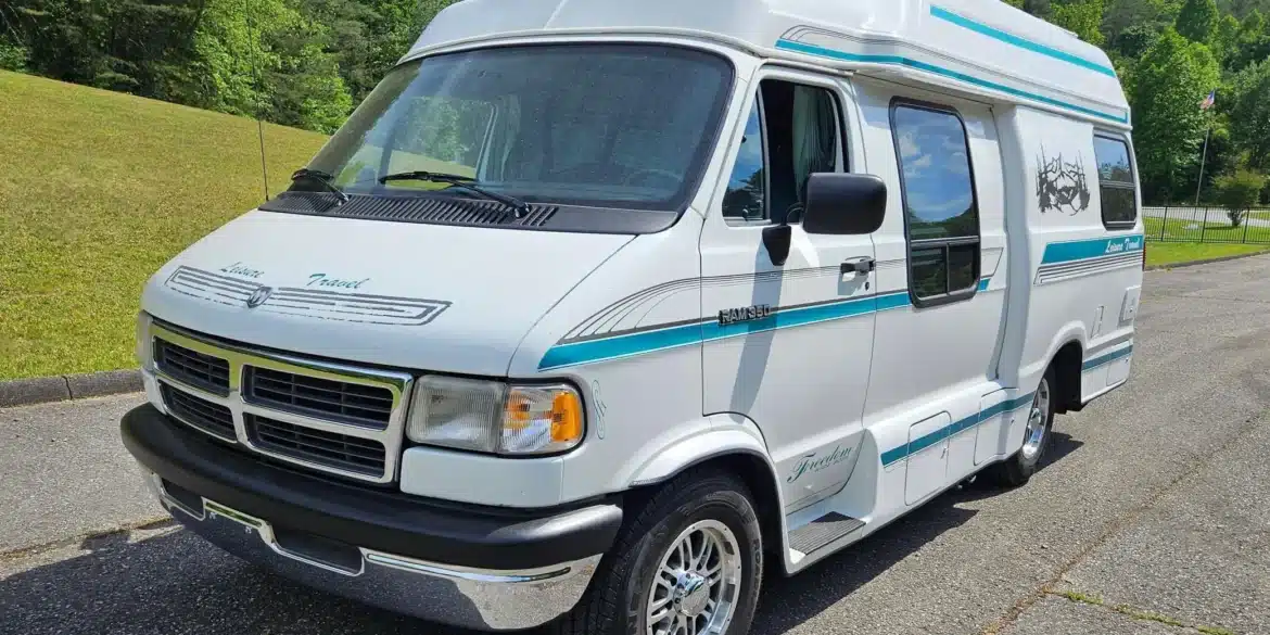 Weißer Dodge Ram Van B350 Leisure Travel als Reisemobil mit Hochdach und blauen Streifen