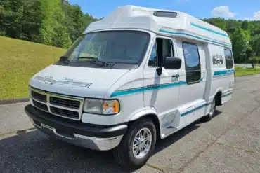 Weißer Dodge Ram Van B350 Leisure Travel als Reisemobil mit Hochdach und blauen Streifen
