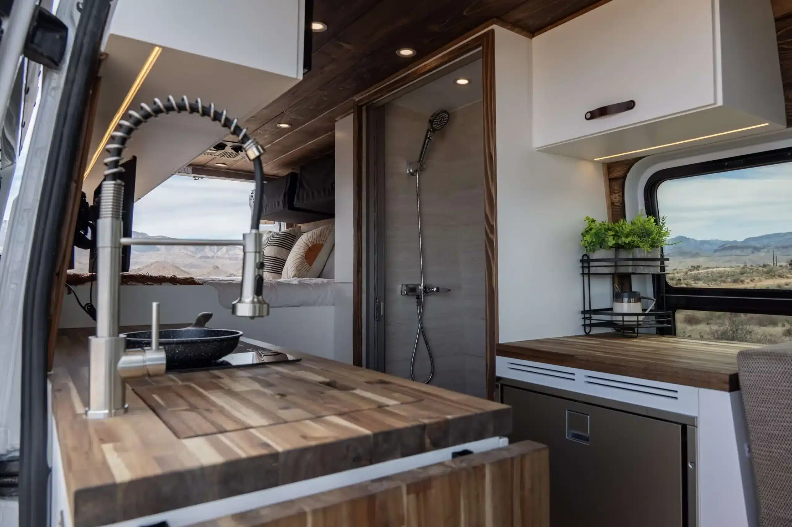 Innenraum des Papago Vans El Capitan mit Akazienholz-Küche, Spüle, Dusche, Bett und Stauraum
