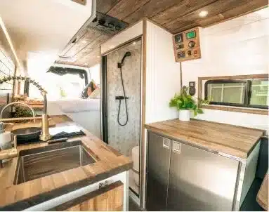 Innenraum des Papago Vans El Capitan mit Akazienholz-Küche, Spülbecken, Dusche und Stauraum
