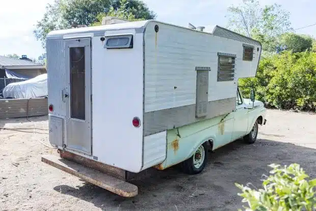 Heckansicht eines mintgrünen Ford F-250 von 1961 mit weißer Wohnkabine und sichtbaren Gebrauchsspuren