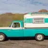 Seitenansicht eines türkis-weißen Ford F-250 Pickup mit weiß-türkisem Slide-In-Camper