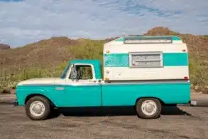 Seitenansicht eines türkis-weißen Ford F-250 Pickup mit weiß-türkisem Slide-In-Camper