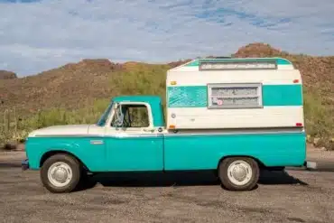 Seitenansicht eines türkis-weißen Ford F-250 Pickup mit weiß-türkisem Slide-In-Camper