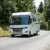 Weißes FRANKIA TITAN Luxus-Reisemobil auf einer kurvigen Waldstraße