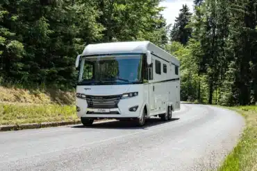 Weißes FRANKIA TITAN Luxus-Reisemobil auf einer kurvigen Waldstraße
