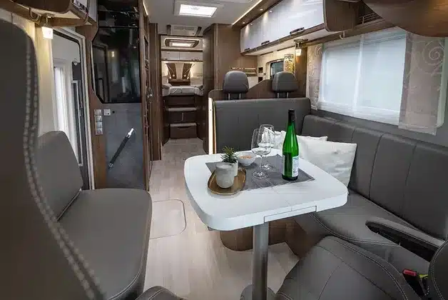 Innenraum eines FRANKIA TITAN Reisemobils mit Sitzgruppe, Esstisch und Küchenbereich