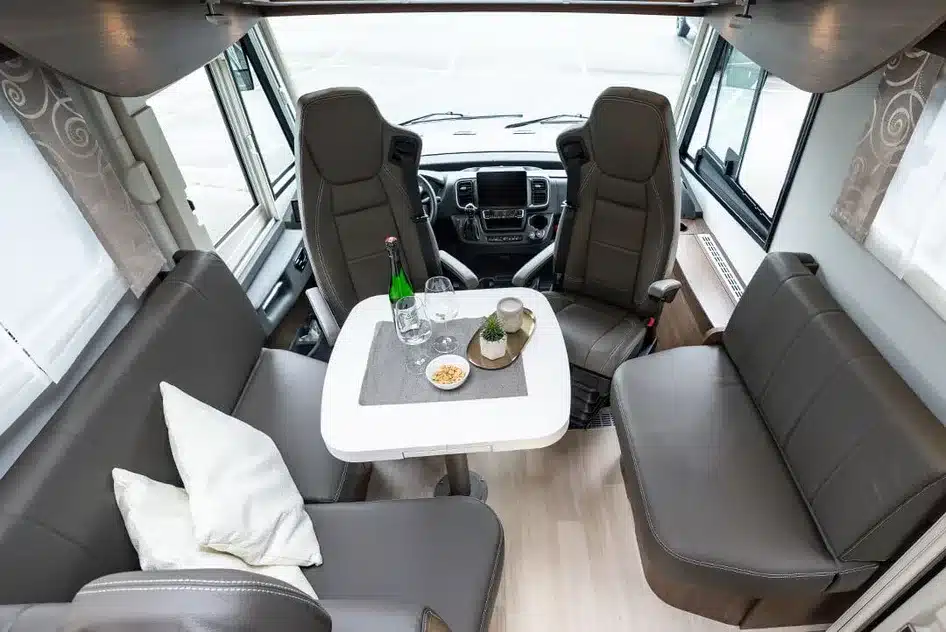 Innenraum eines FRANKIA TITAN Reisemobils mit Sitzgruppe, Esstisch und drehbaren Vordersitzen
