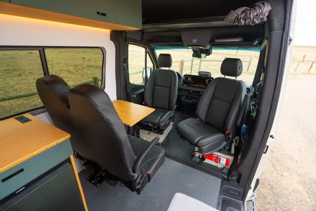 Innenraum eines Geotrek Teton Campervans mit drehbaren Sitzen und Tisch