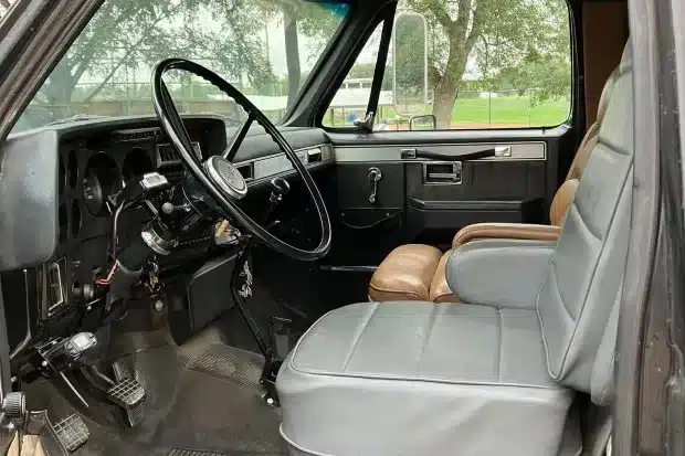Innenansicht des Fahrerhauses eines 1989 GMC C7000 Toterhome mit Lenkrad und grauen Sitzen