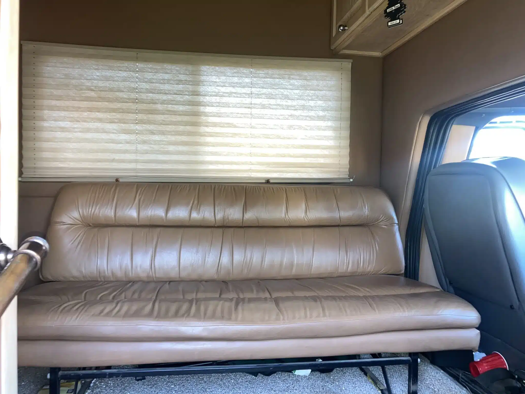 Beige Ledersofa und Jalousie im Innenraum eines GMC C7000 Toterhome