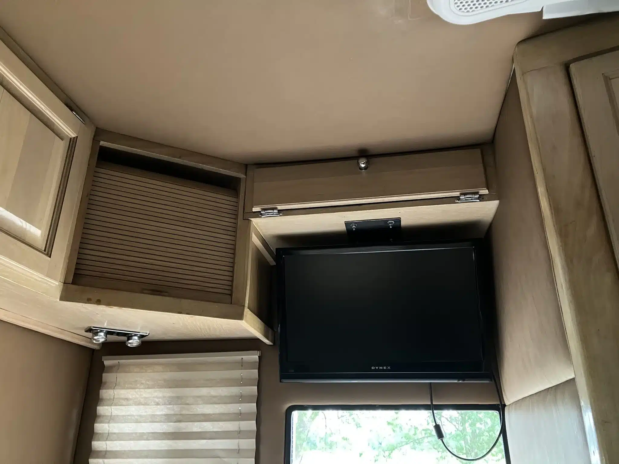 Innenraum eines GMC C7000 Toterhome mit Flachbildfernseher, Holzschränken und Jalousien