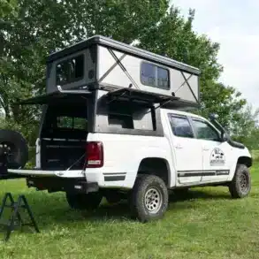 OLC Adventure Hardtop PickUp Camper mit geöffneter Schlafkabine auf einem weißen Offroad-Pickup