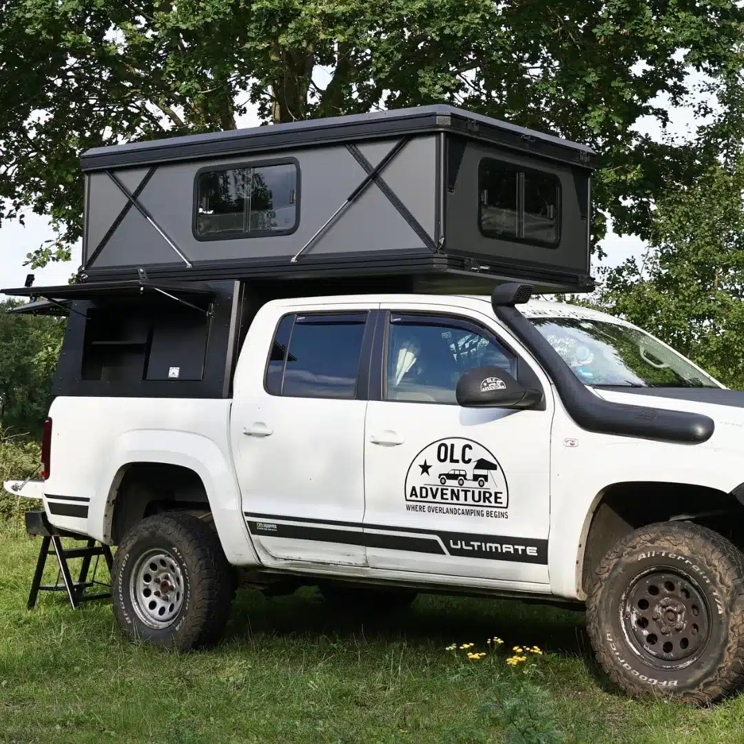 Weißer Offroad-Pickup mit montiertem schwarzem OLC Adventure Hardtop PickUp Camper und seitlichen Fenstern