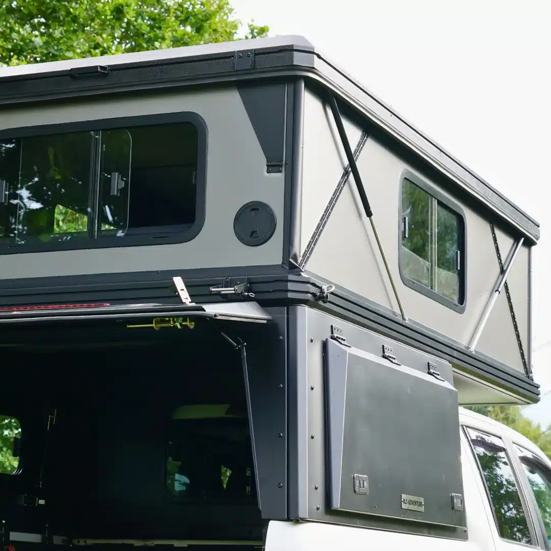 OLC Adventure Hardtop PickUp Camper mit aufgeklappter Schlafkabine, Seitenfenstern und Aluminium-Hardtop auf einem Pickup