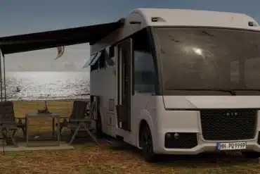 Weißes vollintegriertes HIP 4Family Reisemobil mit ausgefahrener Markise und Campingmöbeln vor einer verschneiten Landschaft