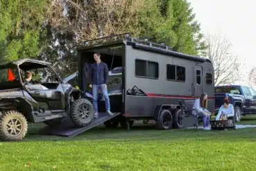 Grauer inTech Flyer Toy-Hauler mit geöffneter Heckrampe und geladenem Side-by-Side-Fahrzeug