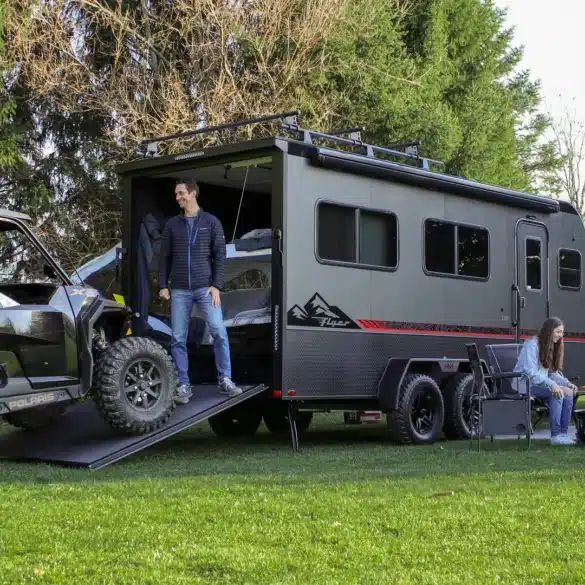 Grauer inTech Flyer Toy-Hauler mit geöffneter Heckrampe und geladenem Side-by-Side-Fahrzeug