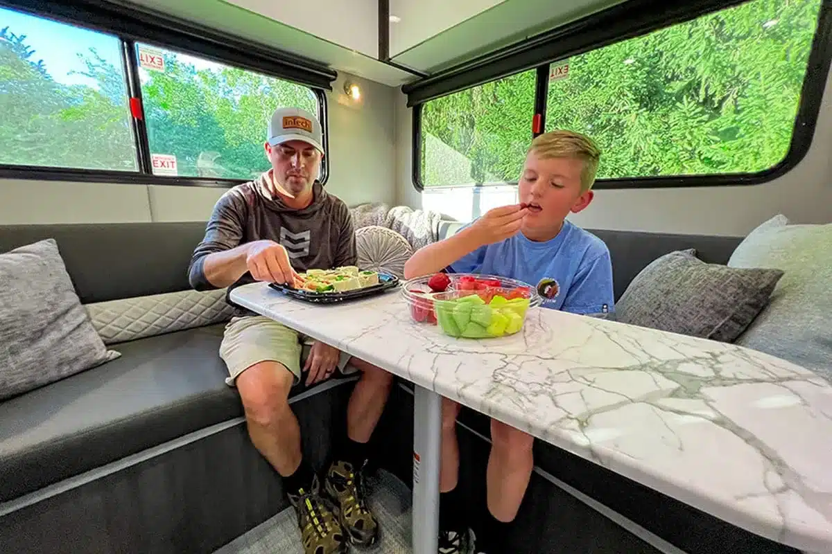 Innenraum eines inTech O-V-R Navigate mit L-förmiger Dinette, Marmortisch und zwei Personen
