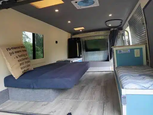 Innenraum des umgebauten Isuzu NPR 4x4 Campers mit Schlafsofa, Sitzbank und Dachlüfter