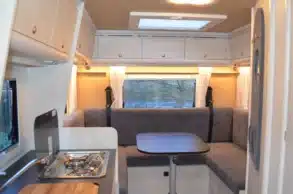Innenraum des Reisemobils Robel K 630 HLB auf MAN TGE mit Sitzgruppe, Tisch und Küchenzeile