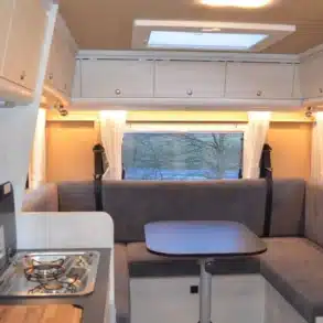 Innenraum des Reisemobils Robel K 630 HLB auf MAN TGE mit Sitzgruppe, Tisch und Küchenzeile