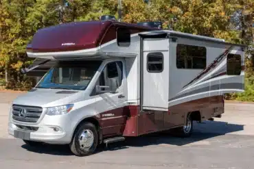 Silber-burgunderfarbenes Mercedes-Benz Sprinter Isata 3 Series Wohnmobil mit Alkoven und ausgefahrenem seitlichem Slide-out