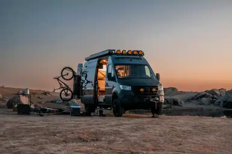 Ausgebauter Mercedes-Benz Sprinter Campervan mit Fahrrädern in felsiger Landschaft