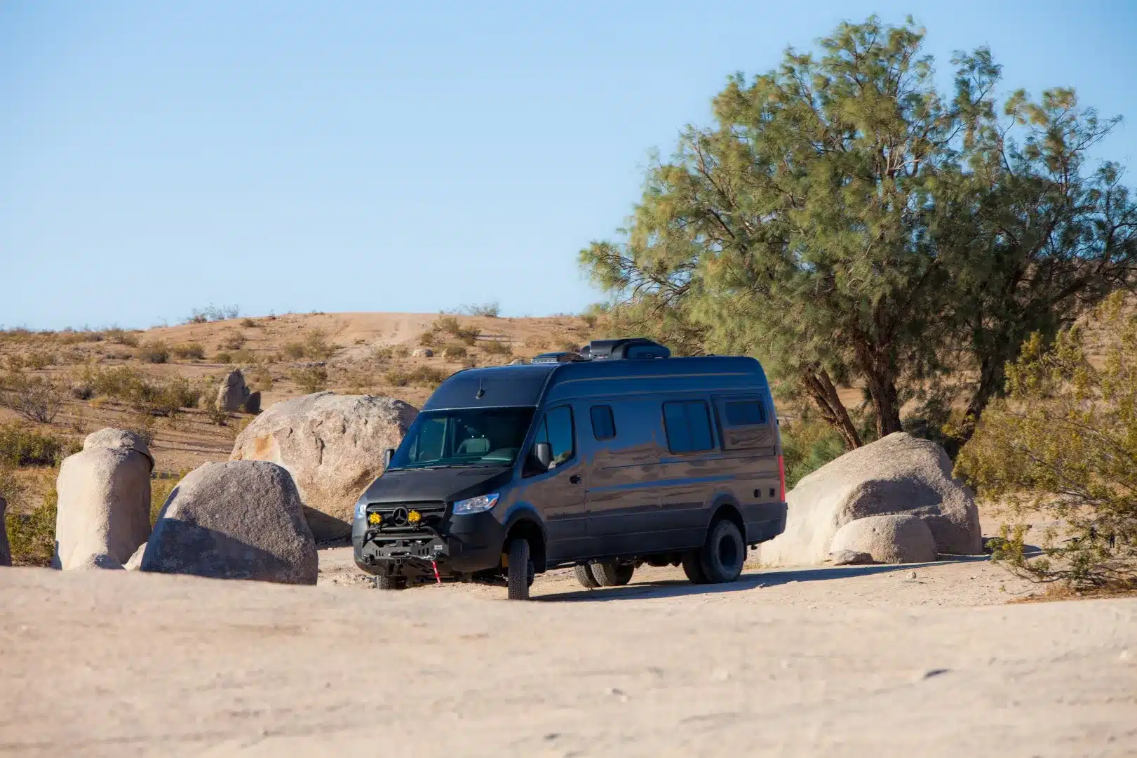 Dunkler Millerton Campervan auf Mercedes-Benz-Sprinter-Basis in felsiger Wüstenlandschaft