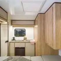 Innenraum des Niewiadow N-Lazur NTL mit Küchenzeile, Kühlschrank, Sitzbereich und Holzschränken